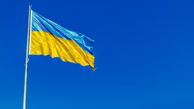 Die ukrainische gelb-blaue Flagge weht im Wind. Nationales Symbol der Ukraine im Himmel