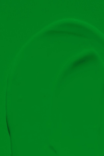 Die undichte Textur der grünen Farbe. Verschmierte Farbe ist eine flüssige grüne Farbe. Die grüne Hintergrundfarbe breitet sich im Licht aus und wird auf die natürliche Grasoberfläche aufgetragen