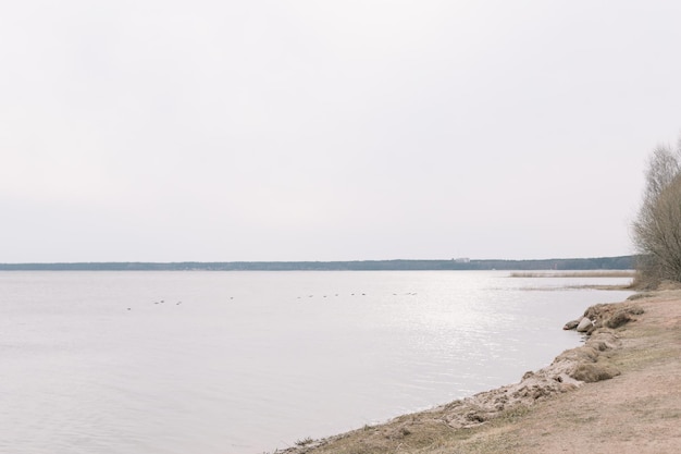 Die unglaubliche Aussicht auf Fluss oder See im Frühjahr Blaue Wasseroberfläche mit kleinen Wellen unter blauem Himmel