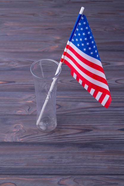 Die US-Flagge in der Glasvase auf grauem Holzschreibtischhintergrund