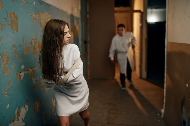 Die verrückte Patientin in Zwangsjacke rennt von der psychiatrischen Klinik des Psychiaters weg.