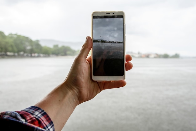 Die Verwendung des Smartphones bei Regenwetter fällt auf den Bildschirm