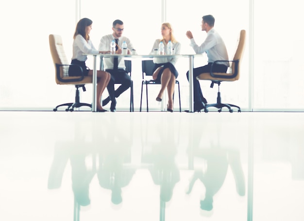 Die vier Geschäftsleute sitzen am Konferenztisch