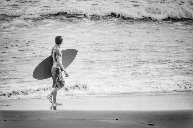 Foto die volle länge einer frau, die am strand steht