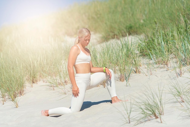 Die volle Länge einer jungen Frau auf dem Sand am Strand