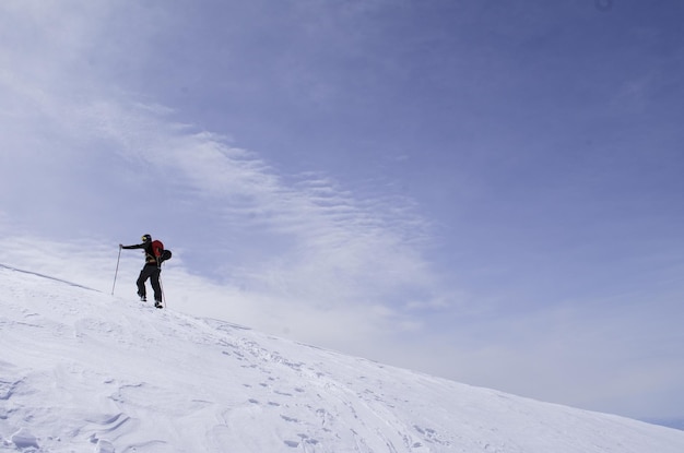 Die volle Länge einer Person auf einem schneebedeckten Berg gegen den Himmel