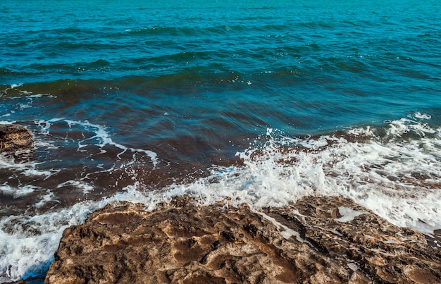 Die Welle bricht auf dem Felsen