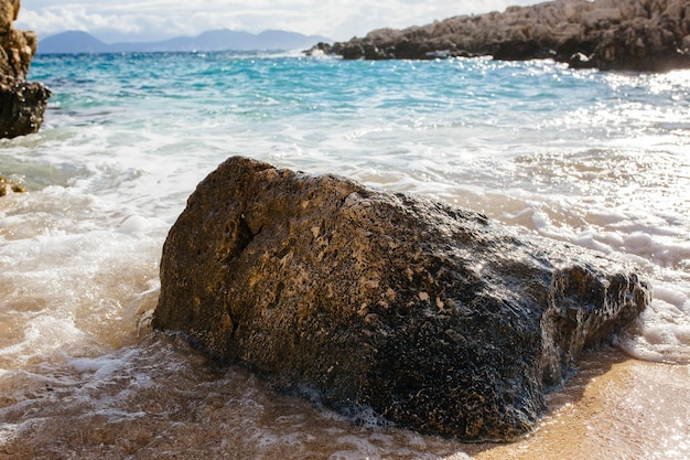 Die Wellen des Meeres am steinigen Strand von Kefalonia