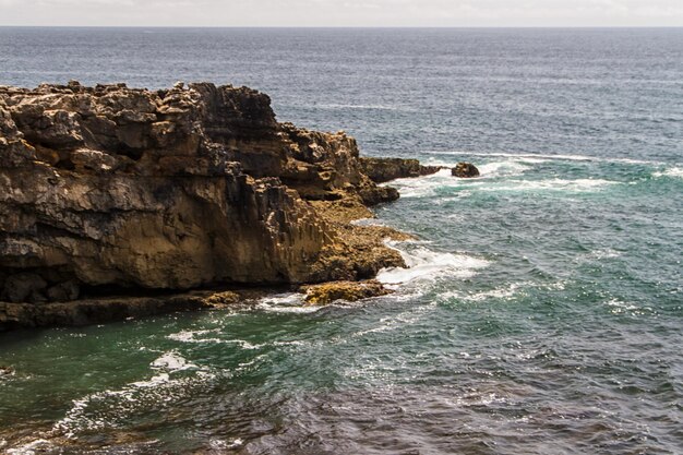 Die Wellen, die um verlassene felsige Küste des Atlantiks Portugal kämpfen