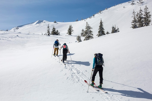 Die Winterberge bieten dieser Gruppe von Skifahrern, die mit Teamwork vorankommen, einen herausfordernden, aber lohnenden Aufstieg