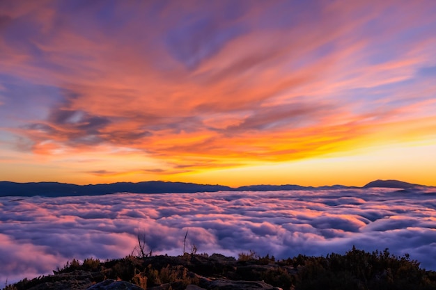 Die Wolken über den Bergen sind wunderschön mit einem Sonnenaufgang und einer sehr harmonischen Atmosphäre