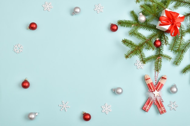 Die Zusammensetzung der Attribute des neuen Jahres. Weihnachtsgeschenke mit einem Tannenzweig auf hellblauem Hintergrund.