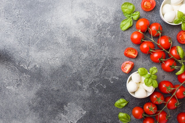 Die Zutaten für einen Caprese-Salat. Basilikum, Mozzarellabälle und Tomaten mit Kopienraum.