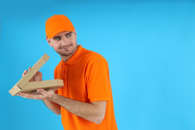 Dieb Lieferbote mit Pizza auf blauem Hintergrund