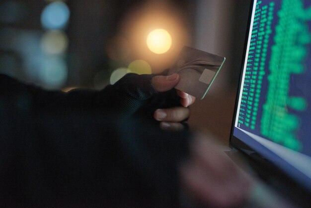 Foto diebstahl der hände eines hackers mit kreditkarte, laptop und zahlenbildschirm, illegale zahlungen oder geldwäsche, cybersicherheit und männliche person, die mit online-software kapital von einem konto stiehlt