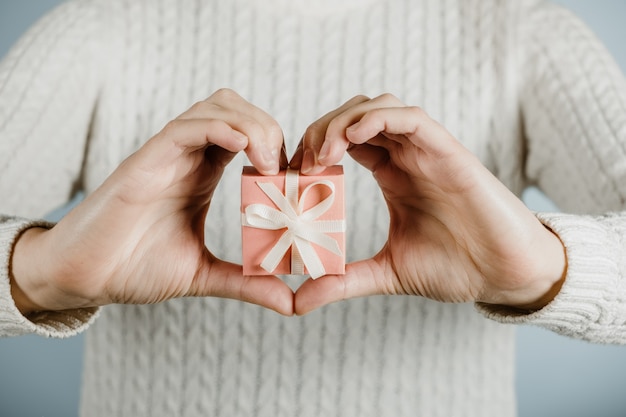 Dienstag geben Hilfe Spende Unterstützung Freiwilligenkonzept mit weiblichen Händen und rosa Geschenkbox an