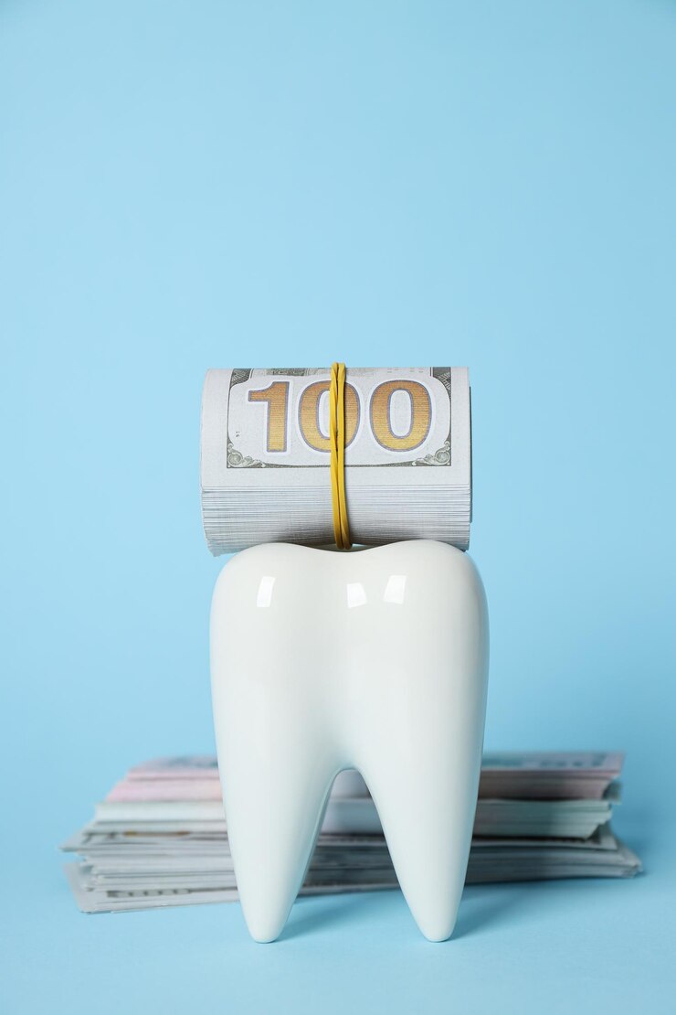 Diente decorativo y dinero sobre fondo azul.