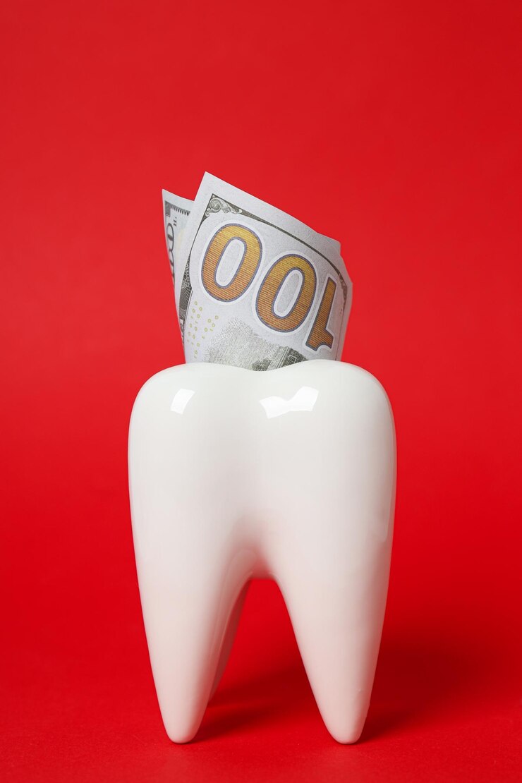 Diente decorativo y dinero sobre fondo rojo.