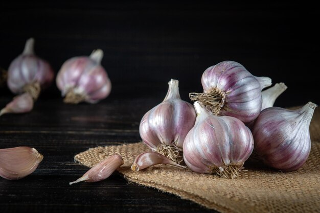 Dientes de ajo pelados y cabezas sobre una arpillera y una mesa para picar antes de cocinar Productos agradables Espacio de copia