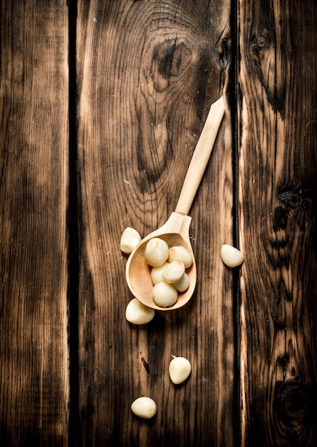 Dientes de ajo pelados en una cuchara de madera