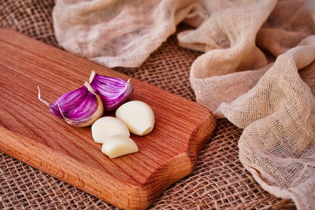 Dientes de ajo en una tabla de madera producto ecológico natural de estilo rústico