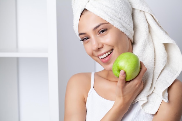 Dientes blancos sanos retrato de mujer sonriente deportiva con manzana verde