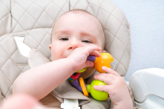 Los dientes de leche del bebé están saliendo, las encías pican. El niño tiene un juguete en la boca.