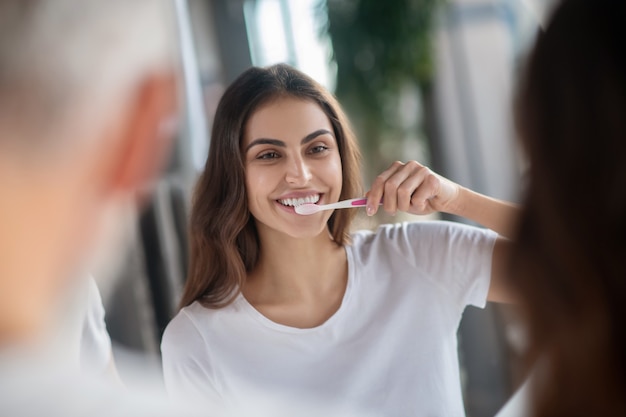 Dientes sanos. Una mujer cepillándose los dientes por la mañana