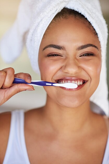 Foto los dientes sanos son dientes felices retrato de una mujer joven feliz y atractiva cepillándose los dientes