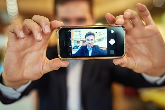 Dies ist eines für das Geschäftsprofil Aufnahme eines jungen Geschäftsmannes, der ein Selfie macht, während er in einem Café sitzt