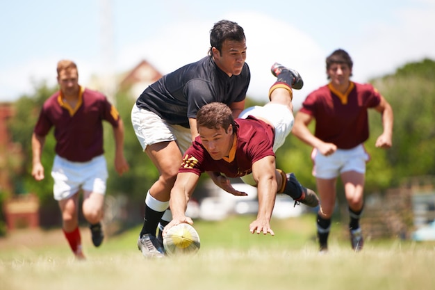 Dieses Spiel ist nichts für schwache Nerven Ganzkörperaufnahme eines jungen Rugbyspielers, der einen Try Mid Tackle erzielt