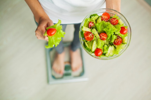 Dieta y alimentación saludable. Joven mujer comiendo ensalada saludable después del ejercicio