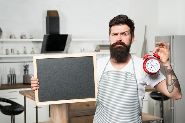 Dieta de ayuno por intervalos Desayuno Hábitos alimenticios Recetas fáciles con pocos ingredientes Hombre con espacio de copia de pizarra Chef de cocina con reloj despertador Hora de comer Hora de la cena Almuerzo Cocinero hipster