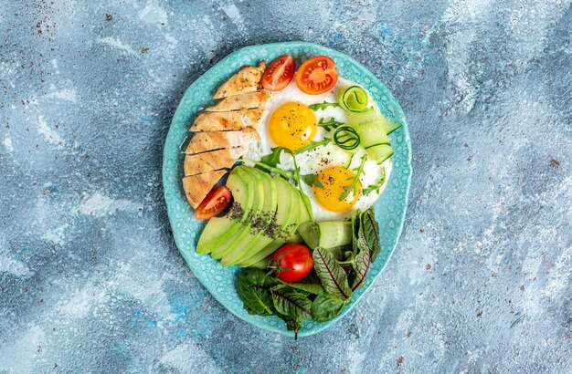 Dieta cetogênica Comida refeição saudável Keto caseiro Filé de frango grelhado com salada tomates frescos pepinos ovos e abacate vista superior