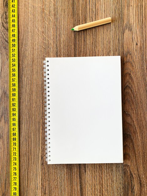 Dieta Cinta métrica sobre fondo de madera con libreta de diario y bolígrafo para un fondo de fitness saludable