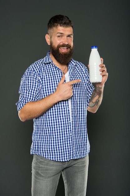 Dieta com lactose hipster caucasiano brutal beber leite cuidados de saúde e dieta produtos lácteos consumindo lactose nutrição saudável iogurte probióticos e prebióticos homem barbudo segura garrafa branca com leite