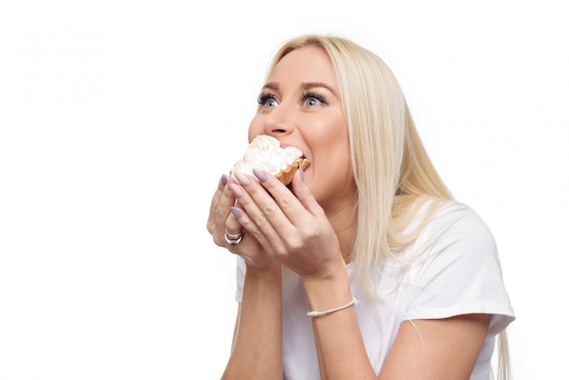 Dieta. Concepto de dieta. Comida sana. Joven rubia mujer en camiseta blanca cómo manos paran en un delicioso pastel. Aislado sobre fondo blanco