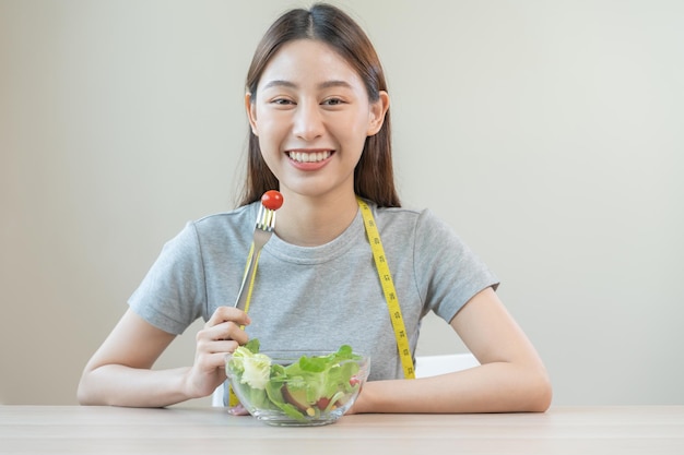 Dieta Dieta mujer joven asiática o niña use tenedor en tomate en verduras mixtas ensaladera verde comer alimentos bajos en grasa buena salud Nutricionista mujer Pérdida de peso para personas sanas