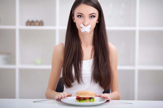 Dieta. La mujer se niega a comer comida chatarra. Concepto de alimentación saludable y estilo de vida activo