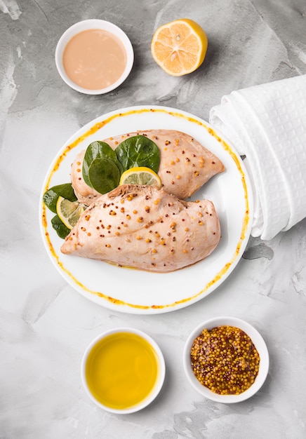 Dieta precocinada filete de pollo en un plato junto a las salsas.