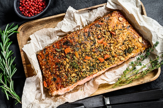 Una dieta saludable alta en proteínas, filete de salmón atlántico ahumado. trucha. Fondo negro, vista desde arriba.