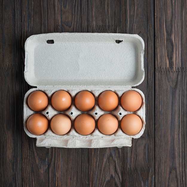 Foto diez huevos marrones en una caja de papel