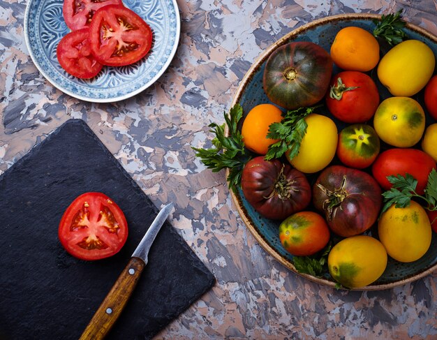 Diferente tipo de tomate en el fondo de hormigón. Enfoque selectivo, vista superior