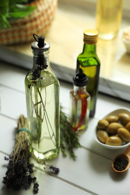 Foto diferentes aceites de cocina e ingredientes en una mesa de madera blanca en el interior