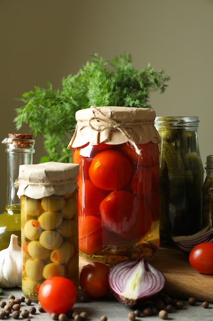 Diferentes alimentos e ingredientes en escabeche en mesa de madera gris