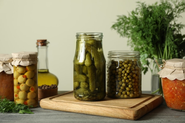 Diferentes alimentos en escabeche en mesa de madera gris