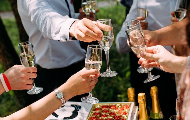 Diferentes amigos juntos levantando copas brindis con champán