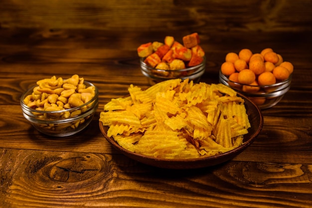 Diferentes bocadillos para cerveza en mesa de madera.