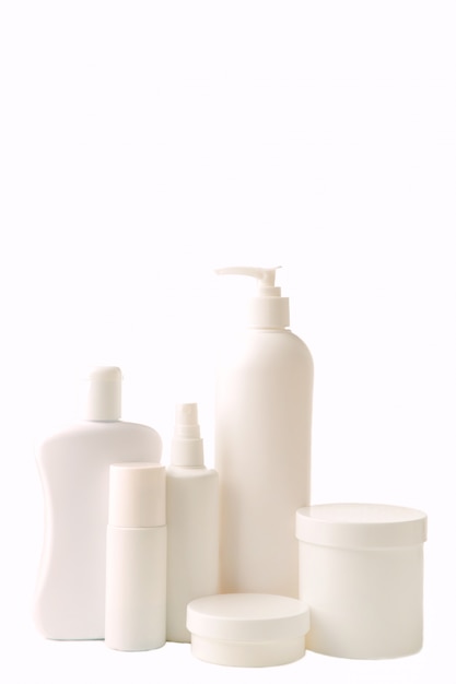 Diferentes botellas de cosméticos aisladas en blanco