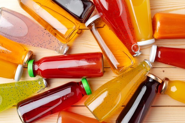 Diferentes botellas de jugo en mesa de madera
